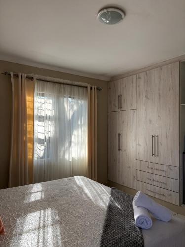a bedroom with a bed and a window at SnaMel's in Waterfall