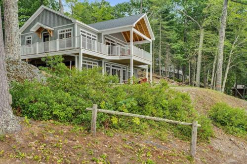 a large house on a hill in the woods at Elegant lakefront home near Bar Harbor & Acadia with modern kitchen, lake views in Orland