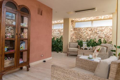 a living room with furniture and a stone wall at Villa Morgana Resort and Spa in Torre Faro