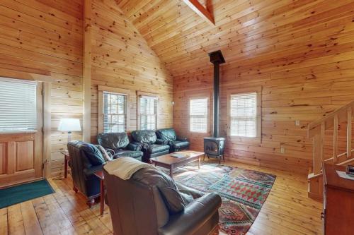 a living room with a couch and a fireplace in a cabin at Charming dog-friendly studio cabin with firepit and near outdoor fun in Northport