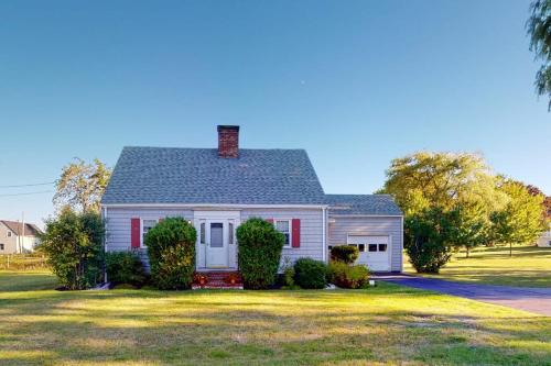 a white house with red shutters on a yard at Comfortable home near the beach - dog-friendly - full kitchen & washer/dryer in Rockland