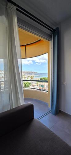 a room with a window with a view of a balcony at Torres del Sol-La Perla- Beachfront & Ocean View in Los Cristianos