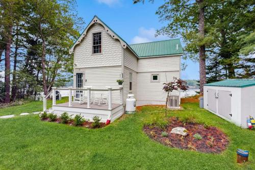 a white house with a deck in the yard at Charming Oceanfront Home with Stunning Water Views and Wifi in Georgetown