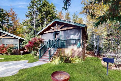 a house with a porch and stairs in the yard at Charming dog-friendly studio cabin with firepit and near outdoor fun in Northport