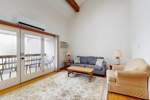 a living room with a couch and a table at Townhome w/ Bonus Loft, High-Speed WiFi, Partial AC & Full Kitchen in Bar Harbor