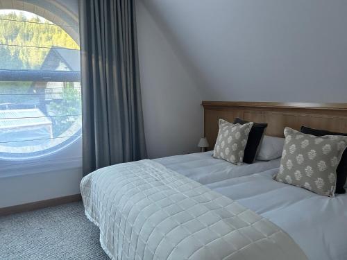 a bedroom with two beds and a large window at Chaty Gorcovia in Nowy Targ