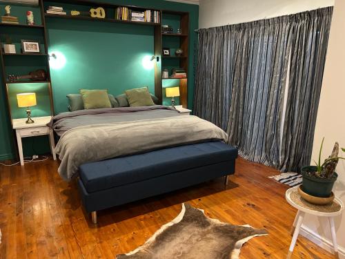 a bedroom with a large bed with a blue wall at Bamboo in George
