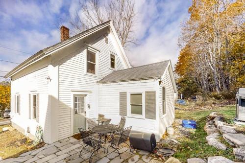 a small white house with a table and chairs at Coastal home with new, full kitchen, walkable downtown location in Boothbay Harbor