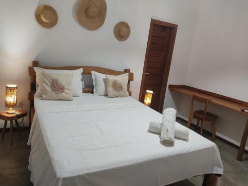 a bedroom with a white bed with towels on it at Suítes em praça pontal de Maceió in Fortim