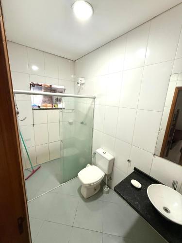 a bathroom with a toilet and a shower and a sink at Rancho Camiotto in Rubinéia