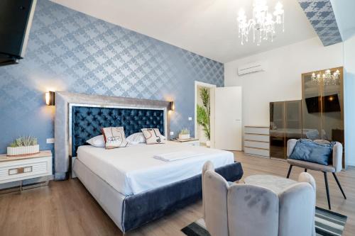 a bedroom with a large bed and two chairs at Kalpazo White Stones in Palasë