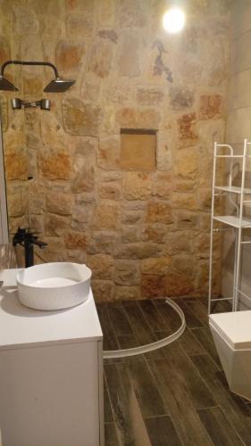 a bathroom with a sink and a stone wall at Khalle Lodge in Dayr al Qamar