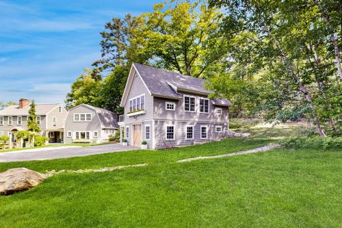 a house with a large yard with green grass at Brand new guest apartment with furnished deck, fast WIFI, dock, & water views in Boothbay Harbor