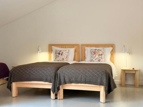 a bedroom with two beds with pillows and two lamps at Grota Lodging in Leiria