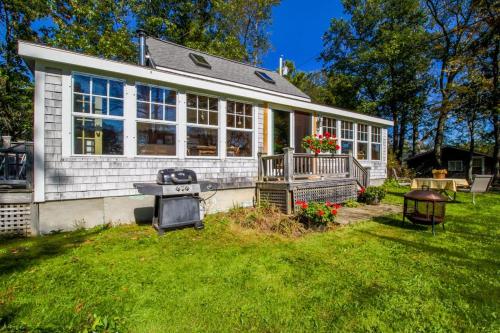 a small house with a grill in the yard at Charming Bayview Cottage with Deck, Firepit, Garden - 200 in East Harpswell