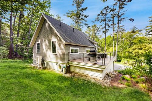 a house with a large deck in the yard at Brand new guest apartment with furnished deck, fast WIFI, dock, & water views in Boothbay Harbor