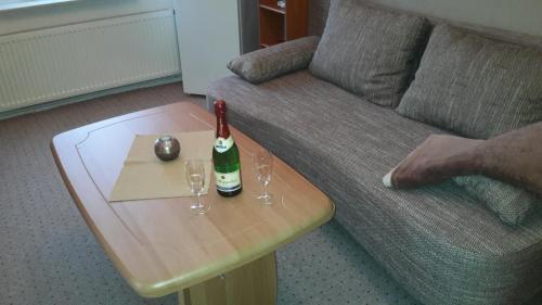 a bottle of champagne on a table next to a couch at Pension Lemke in Polchow