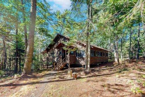 a cabin in the middle of a forest at Stunning log cabin with fireplace & nature views - near shopping & dining in Boothbay Harbor