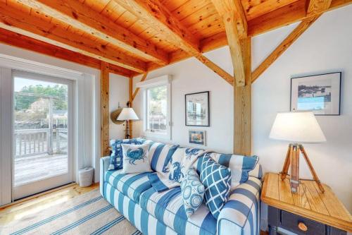 a living room with a couch and a table at Oceanfront Cottage & Studio on Mill Cove w/ Water Views, Deck - Walk Downtown in Boothbay Harbor
