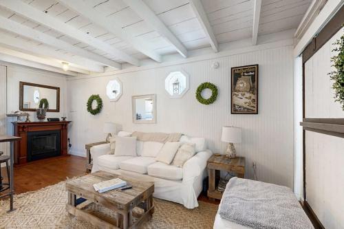 a living room with a white couch and a table at Iconic downtown retreat with firepit & fireplace- walk to Harbor Footbridge in Boothbay Harbor
