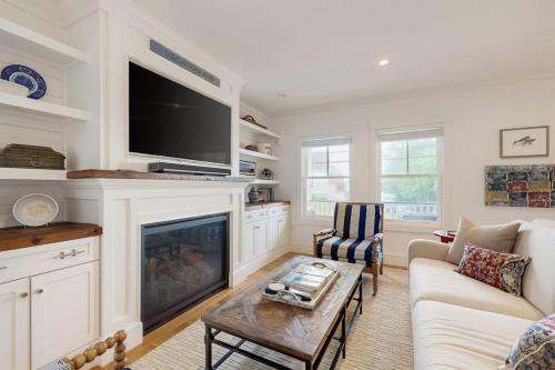a living room with a fireplace and a tv at Elegant home with veranda & water view, walk to downtown Boothbay Harbor in Boothbay Harbor