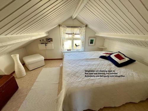 a bedroom with a large white bed in a attic at Bagarestigen bargel punkt s e in Lysekil