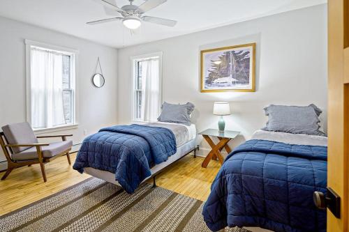 a bedroom with two beds and a ceiling fan at Waterfront Duplex, walkable, harbor views, AC, dog friendly in Camden