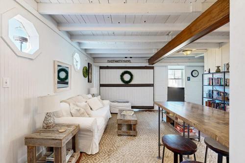 a living room with a white couch and a table at Iconic downtown retreat with firepit & fireplace- walk to Harbor Footbridge in Boothbay Harbor