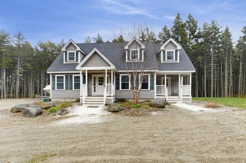 a small white house in the middle of a yard at Secluded Dog-Friendly Getaway w/ Free WiFi, Private Washer/Dryer, Furnished Deck in Southport