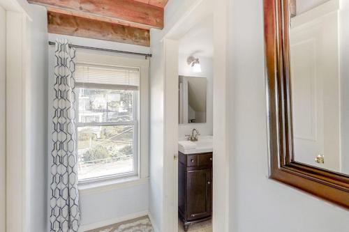 a bathroom with a window and a sink and a mirror at Oceanfront house with dock, kayaks, deck, and gas grill in Boothbay Harbor