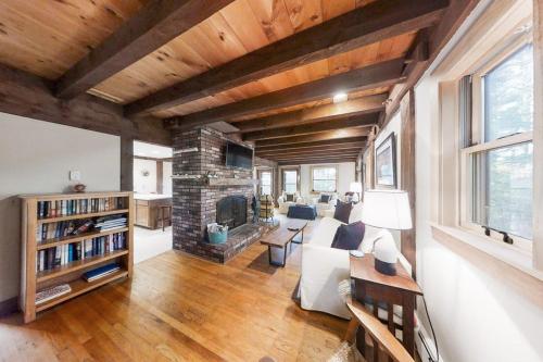 a living room with a couch and a fireplace at Appalachee Pond Waterfront Cottage | Decks, Sunroom, Dock with Kayaks & Canoe in Boothbay Harbor