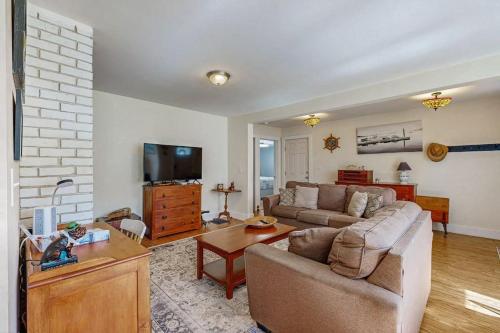 a living room with a couch and a table at Coastal bungalow with large yard, beautiful kitchen, & great location in Boothbay Harbor