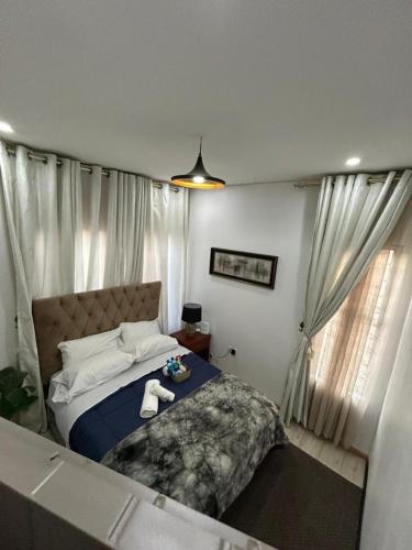a bedroom with a bed and a window with curtains at Serenity Haven in Chongwe