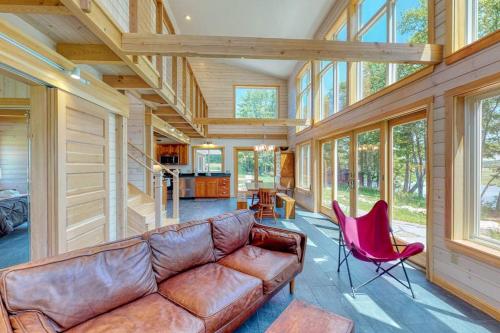 ein Wohnzimmer mit einer braunen Ledercouch und Sesseln in der Unterkunft Bayfront home with gorgeous water views, dock, outdoor patio, fireplace in Bowdoinham
