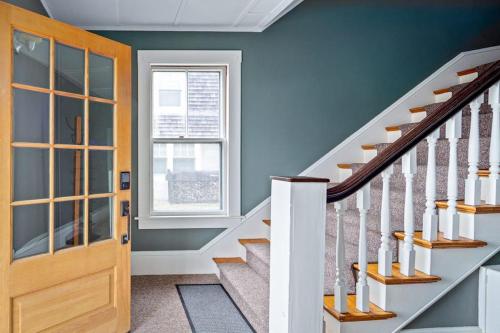 a staircase with blue walls and a wooden door at Waterfront, walkable, updated home with harbor views & partial AC in Camden