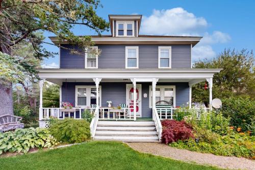 a blue house with a front porch and a yard at Charming Coastal Retreat with Ocean Views, Porch and Private Cabin in Sullivan