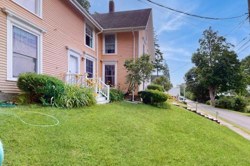 a house with a green lawn in front of it at Cozy apartment with harbor view - full kitchen & washer/dryer - walk to water in Rockport