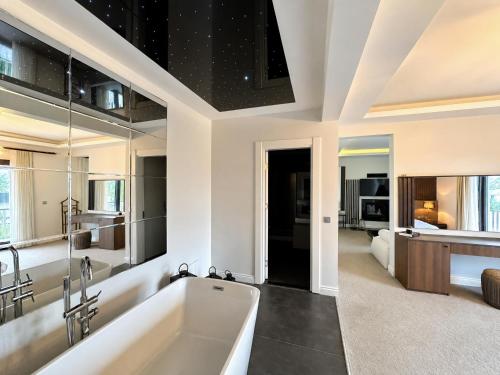 a bathroom with a white tub and a bedroom at Didi Hotel Sapanca in Sapanca