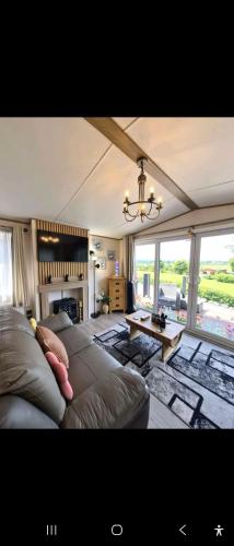 ein Wohnzimmer mit Sofa und Kamin in der Unterkunft The Lodge-Static Holiday Lodge in Carnforth