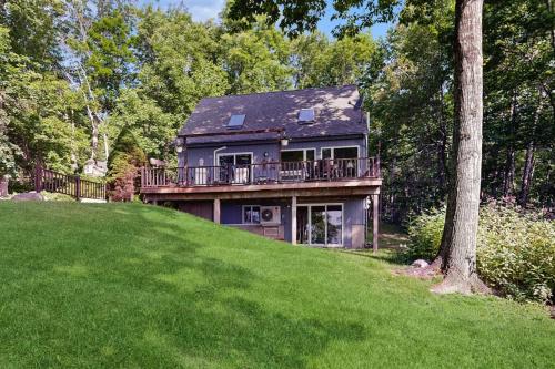 a house on a hill with a balcony on it at Oceanfront snowbird-friendly home on the beach with washer/dryer & fireplace in Lincolnville