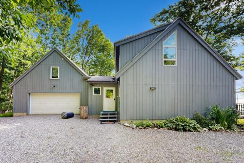a gray house with a garage at Oceanfront snowbird-friendly home on the beach with washer/dryer & fireplace in Lincolnville
