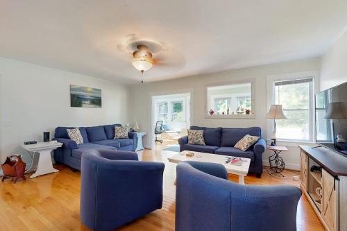 a living room with blue couches and a table at Charming Cottage with Cozy Comfort and Easy Access to Outdoor Adventures in North Lamoine