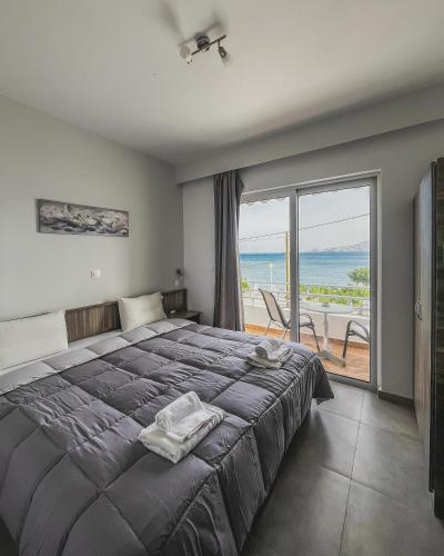a bedroom with a bed and a view of the ocean at Joanna Apartments in Haraki