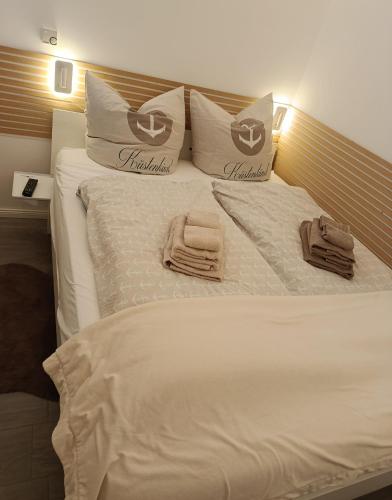 a white bed with two towels on top of it at Saltwater Hohwacht in Hohwacht