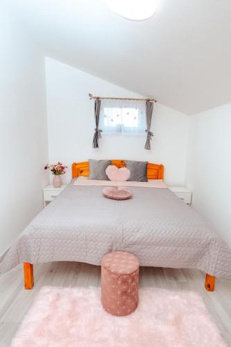 a bedroom with a large bed with a pink rug at Déjá-Vu Apartmanház in Szigetvár