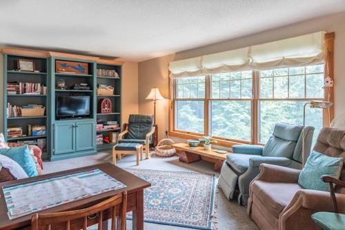 a living room with a couch and a table at Gorgeous lakefront home w/ dock, canoe, kayaks & lake/forest views in Ellsworth
