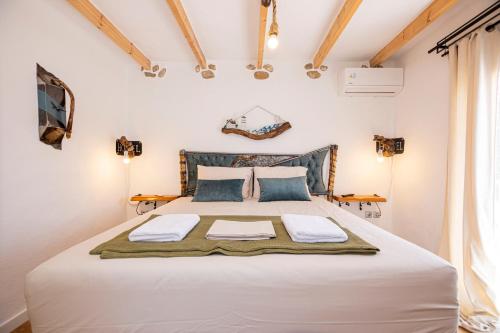 a bedroom with a large white bed with blue pillows at Villa Sofia in Evkarpía