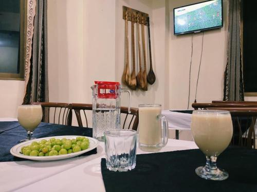 a table with a plate of grapes and a pitcher of milk at Yasin Holiday Hotel in Gilgit