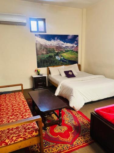 a bedroom with two beds and a painting on the wall at Yasin Holiday Hotel in Gilgit