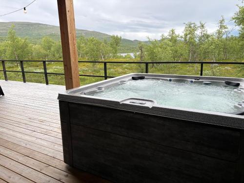 a hot tub on a wooden deck with a view at Sunrise View Lapland, Jacuzzi and sky view in Kilpisjärvi
